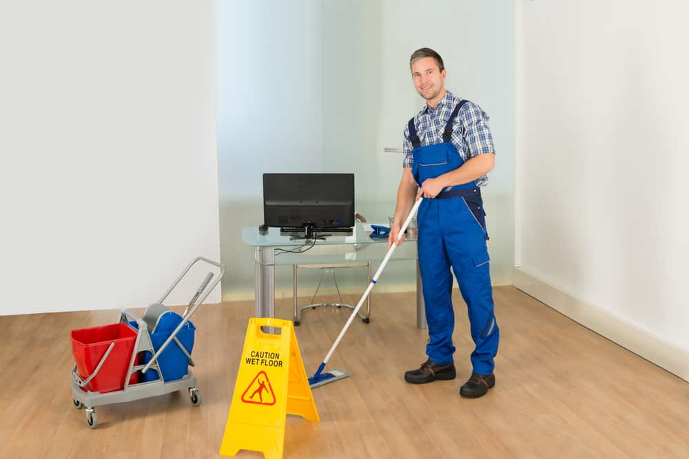 portrait,of,a,male,janitor,cleaning,office,with,mop,and