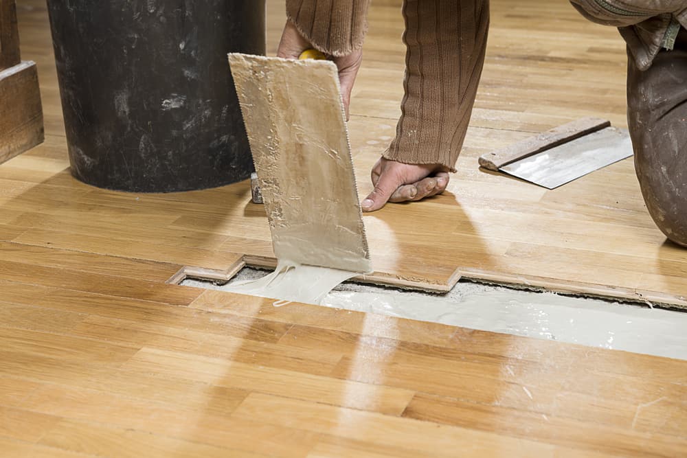 carpenter,applying,parquet,glue